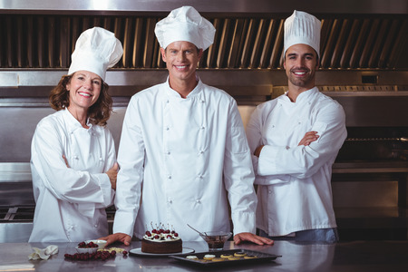 Chefs happy and proud to present the cake they just made in a restaurantの写真素材