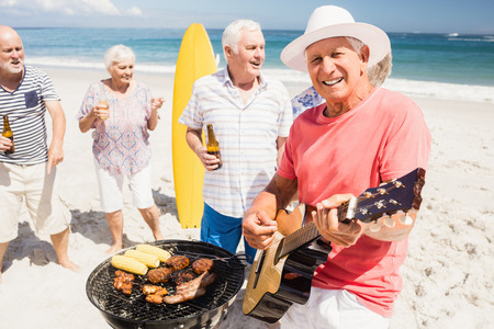 Senior friends having a barbecue on the beachの写真素材