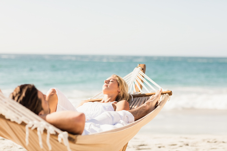 Couple sleeping in hammock on the beachの写真素材