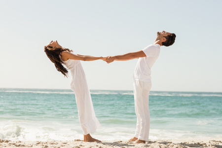 Young couple holding hands on the beachの写真素材