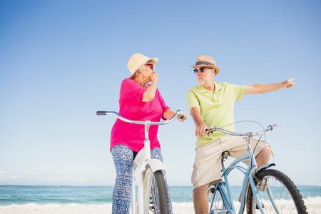 Senior couple going for a bike ride on the beachの写真素材