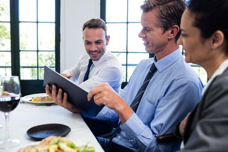 Business colleagues looking at a file and discussing in restaurant