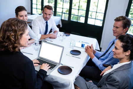 Business colleagues discussing during a lunch meeting in restaurantの写真素材