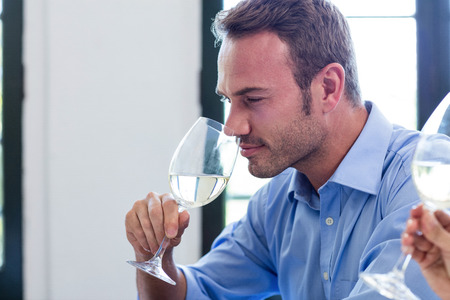 Young man having wine in a restaurantの写真素材