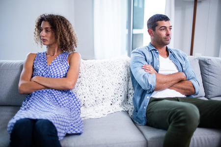 Upset young couple ignoring each other at homeの写真素材
