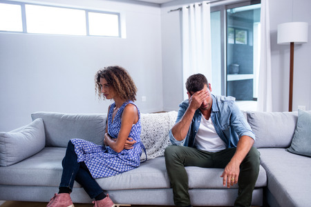 Upset young couple ignoring each other at homeの写真素材