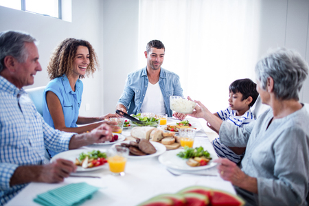Happy family having breakfast together at homeの写真素材