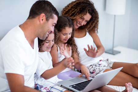 Family having video chat on laptop at homeの写真素材
