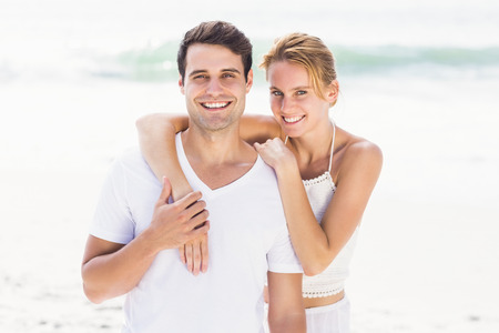 Happy couple embracing each other on the beach on a sunny dayの写真素材