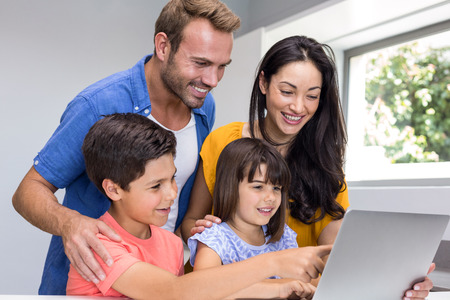 Happy family interacting using laptop in their living room