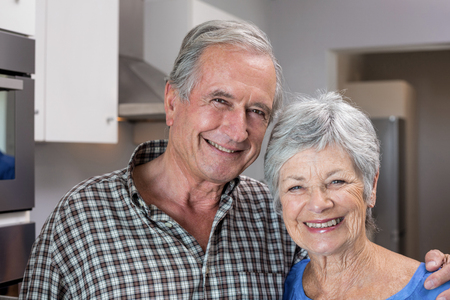 Portrait of elderly man and woman standing in the kitchen
