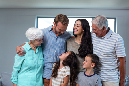 Portrait of happy family standing together and smiling in living room