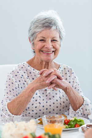 Elderly woman having breakfast in the morningの写真素材