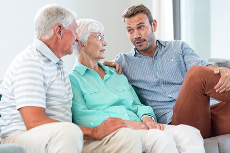 Happy family sitting on sofa in their living roomの写真素材