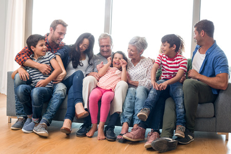 Happy family sitting on sofa in their living roomの写真素材