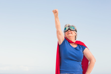 Senior woman wearing superwoman costume on a sunny dayの写真素材