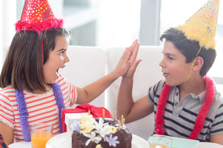 Siblings celebrating birthday at homeの写真素材