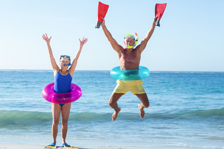 Senior couple with beach equipment at the beachの写真素材