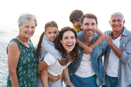 Happy family posing at the beach on a sunny dayの写真素材
