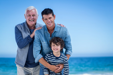 Male family members posing at the beach on a sunny day