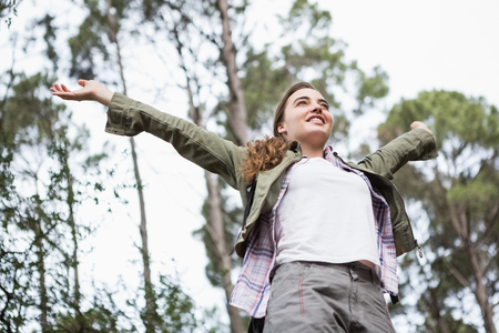 Smiling woman with arms up in the countrysideの写真素材