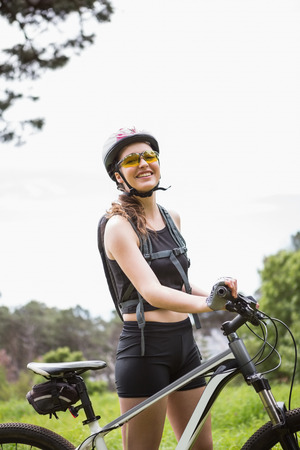 Woman standing next to her bike in the countrysideの写真素材