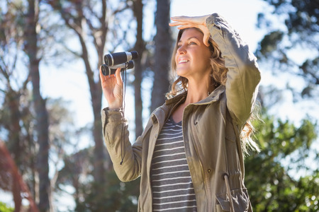 Woman holding binoculars in the countrysideの写真素材