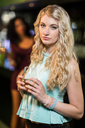 Portrait of smiling blonde woman in a barの写真素材