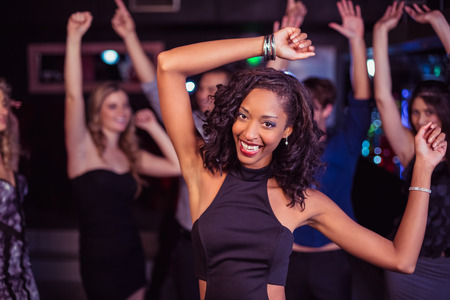 Cute friends having fun and dancing in a nightclubの写真素材