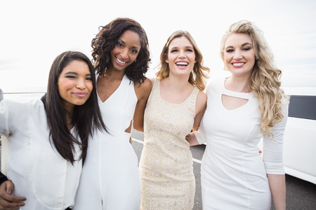 Well dressed men posing next to a limousine on a night outの写真素材