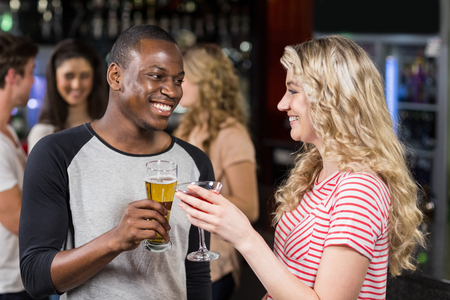 Friends toasting with cocktail and beer in a pubの写真素材
