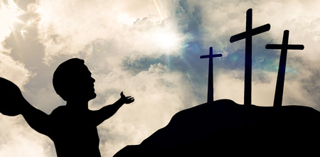 Smiling man standing arms outstretched against cross religion symbol shape over sunset skyの写真素材