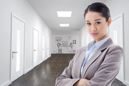 Portrait of a gorgeous businesswoman posing with the arms crossed against doodle office in hallwayの写真素材