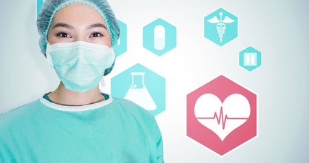Portrait of surgeon woman against medical icons in hexagons interface menuの写真素材