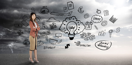 Smiling businesswoman with crossed arms against ominous landscapeの写真素材