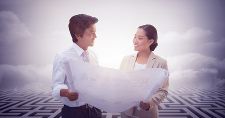 Estate agent looking at blueprint with potential buyer against maze ending in cloudy skyの写真素材