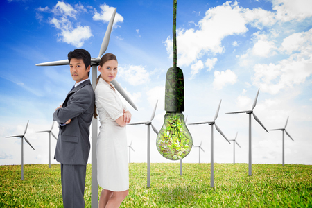 Portrait of business people standing back-to-back against renewable and clean energyの写真素材