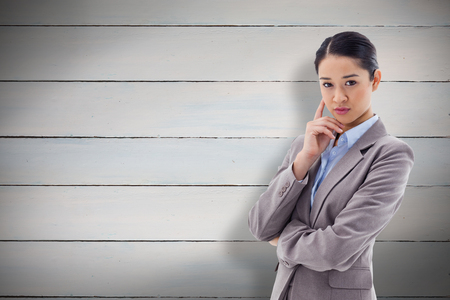 Portrait of a young businesswoman thinking against painted blue wooden planksの写真素材