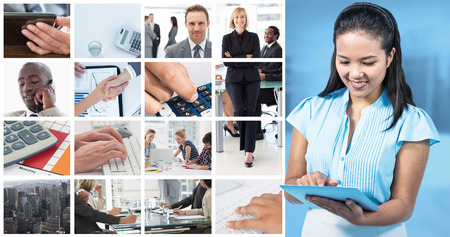 Smiling businesswoman using digital tablet  against modern room overlooking cityの写真素材