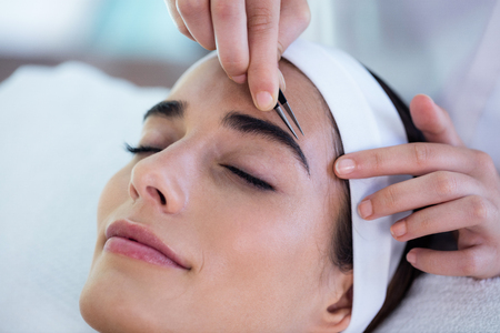 Woman getting her eyebrows shaped at spaの写真素材