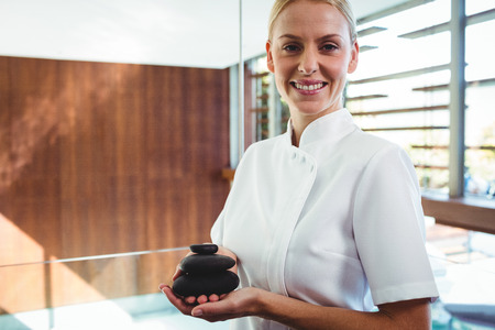 Masseuse holding stones massage at spaの写真素材