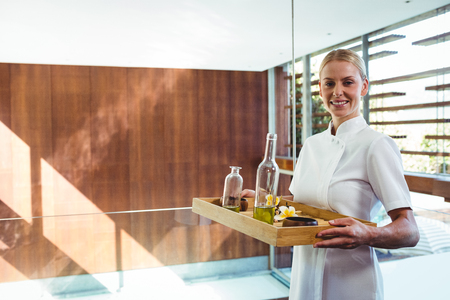 Smiling masseuse holding a tray at the spaの写真素材