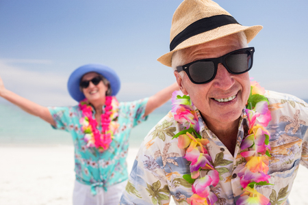 Happy senior couple having fun together on the beach on a sunny dayの写真素材