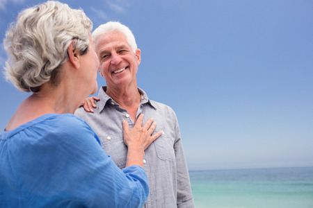 Senior couple embracing each other on the beach on a sunny dayの写真素材