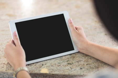 Woman holding a digital tablet in the kitchen at homeの写真素材
