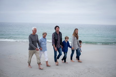 Family walking together on the beach on a sunny dayの写真素材