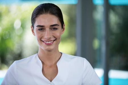 Portrait of confident female masseur standing in spaの写真素材