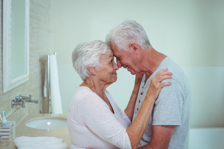 Romantic senior couple touching nose in bathroomの写真素材