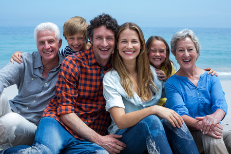 Portrait of cheerful multi-generation family relaxing at beach