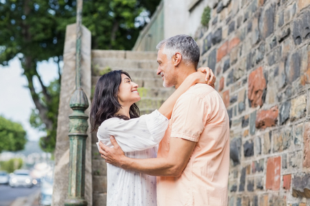 Couple embracing each other while standing in cityの写真素材